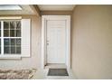 Close-up of the inviting front door with white trim and a welcoming mat at 109 Pecan Pass, Ocala, FL 34472