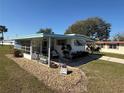 Inviting home with a covered porch and well-maintained landscaping enhancing its curb appeal at 1127 Belmont Cir, Tavares, FL 32778