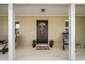 Inviting covered front porch with brick accent, decorative plants and rocking chairs at 1391 E Crooked Lake Dr, Eustis, FL 32726