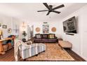 Comfortable living room with leather sofa, stylish armchair, and a modern ceiling fan at 1391 E Crooked Lake Dr, Eustis, FL 32726