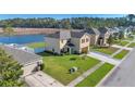 Areal view of a two-story house with well-maintained lawn, and a scenic lake in the neighborhood at 16707 Broadford Ln, Clermont, FL 34714