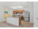 Modern kitchen featuring stainless steel appliances, granite countertops, island and wooden cabinets at 16707 Broadford Ln, Clermont, FL 34714