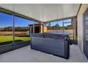 Relaxing screened patio featuring a modern hot tub and view of the expansive backyard and pond at 16707 Broadford Ln, Clermont, FL 34714