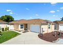 Charming single-story home featuring a well-manicured lawn, welcoming walkway, and attached garage at 1685 Garcia Ct, The Villages, FL 32159