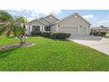 Well-maintained single-story home featuring a 3-car garage, lush lawn, and mature palm tree at 17378 Se 110Th Ter, Summerfield, FL 34491