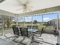 Relaxing screened-in lanai with a ceiling fan, table and chairs overlooking a serene view at 17378 Se 110Th Ter, Summerfield, FL 34491