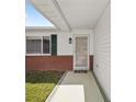 Inviting front entryway with a charming storm door, green shutters and brick accents at 17834 Se 105Th Ave, Summerfield, FL 34491