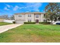 Charming two-story home with a well-manicured lawn and lush greenery at 1787 Sunset Ridge Dr, Mascotte, FL 34753