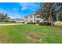 Charming two-story home with a well-manicured lawn and lush greenery at 1787 Sunset Ridge Dr, Mascotte, FL 34753