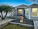 Well-manicured front yard featuring tropical landscaping, a garden statue, and an inviting entrance at 2082 Vision Ct, The Villages, FL 32163