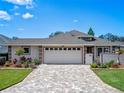 Inviting home featuring manicured landscaping and paved driveway to an attached two-car garage at 21849 Tartan St, Leesburg, FL 34748