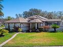 Inviting home with well-maintained lawn and beautiful tropical plants at 21850 Tartan St, Leesburg, FL 34748