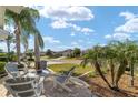 Serene outdoor seating area with comfortable chairs, table, umbrella and beautiful neighborhood views at 2279 Lowell Ter, The Villages, FL 32162