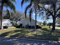 Landscaped home exterior with green lawn and mature trees at 25124 Twelve Oaks Rd, Leesburg, FL 34748