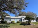 Well-maintained single-story home with aqua shutters and door at 25124 Twelve Oaks Rd, Leesburg, FL 34748