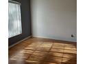 Bright bedroom with hardwood floors, grey accent wall, and natural light streaming through window at 25212 Clifford Hl, Leesburg, FL 34748