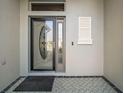 Close-up of the elegant front door with decorative glass and sidelight, showcasing the entrance detail at 2882 Adrienne Way, The Villages, FL 32163