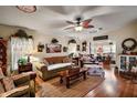 Cozy living room featuring a ceiling fan, hardwood floors and eclectic decorations at 313 Westwood Dr, Leesburg, FL 34748