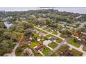 An aerial view of a residential neighborhood with mature trees and a lake in the distance at 330 N Sunset Dr, Mount Dora, FL 32757