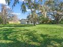 Green backyard featuring a single story home with a light paint scheme and well maintained yard at 422 W Hunt Ave, Bushnell, FL 33513