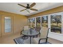 Sunroom with scenic backyard views, a ceiling fan, a glass topped table, and comfortable seating at 4331 Arlington Ridge Blvd, Leesburg, FL 34748