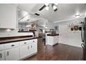 Spacious kitchen featuring dark wood floors, white cabinets and an open design leading to the living room at 50 Se Pecan Run Crse, Ocala, FL 34472