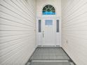 Close-up of the front door with sidelights and transom window and gray tile landing at 613 Sherwood St, The Villages, FL 32162