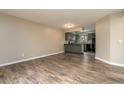 Spacious living room showcasing wood floors and a view of the adjacent kitchen with black appliances at 7266 Swallow Run # 7266, Winter Park, FL 32792