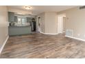 A bright and airy living room with wood flooring, seamlessly flowing into the kitchen area at 7266 Swallow Run # 7266, Winter Park, FL 32792