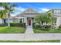 Charming one-story home featuring a well-manicured lawn, and tropical landscaping at 909 Egrets Landing Way, Groveland, FL 34736