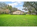 View of the property from backyard with a large manicured lawn at 10122 Canterbury Dr, Leesburg, FL 34788
