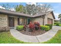 Close up on front yard with a brick facade, landscaped yard, and a walkway at 10122 Canterbury Dr, Leesburg, FL 34788