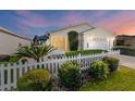 Beautiful home exterior showcasing the manicured front yard, white picket fence, and serene landscaping at 1060 Pinewood Pl, The Villages, FL 32162