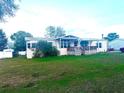 Inviting single-story home with a cozy porch, a metal roof, and a well-maintained lawn at 11428 Pheasant Trl, Leesburg, FL 34788