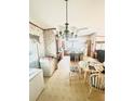 Eat-in kitchen with wood cabinets, a breakfast bar, and a charming chandelier above the dining table at 11428 Pheasant Trl, Leesburg, FL 34788