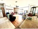 Cozy living room featuring a brick fireplace, hardwood floors, and an open layout at 11428 Pheasant Trl, Leesburg, FL 34788