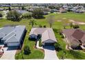 A well-maintained house with manicured lawn, landscaped walkway, and attached two-car garage at 12199 Se 175Th Loop, Summerfield, FL 34491