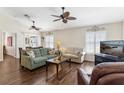 Cozy living room with hardwood floors, ceiling fans, and comfortable seating near bright windows at 12199 Se 175Th Loop, Summerfield, FL 34491