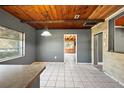 View of dining room with a tile floor, wood plank ceiling, and access to other rooms at 1301 N Shore Dr, Leesburg, FL 34748