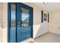 Close-up of a stylish blue front door with decorative glass panels and complementary exterior siding at 1323 Arredondo Dr, The Villages, FL 32162