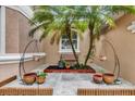 Courtyard with two palm trees, bench, hanging flower pots, and tile at 1602 Oak Hollow Rd, Clermont, FL 34711