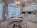 Bright breakfast nook featuring a round table, white cabinets, and backsplash at 17694 Se 88Th Covington Cir, The Villages, FL 32162
