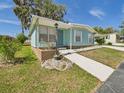 Well-maintained home featuring a covered front entrance, mature landscaping, and a welcoming pathway to the front door at 2 Heather Ln, Fruitland Park, FL 34731