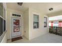 Covered front porch with a glass front door, offering natural light and creating an inviting entrance to the home at 22027 Belgian Ct, Mount Dora, FL 32757