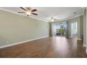 Spacious living room with wood-look tile flooring, two ceiling fans, and sliding glass doors to the outdoor space at 22027 Belgian Ct, Mount Dora, FL 32757