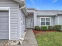 Inviting home entrance with a covered porch, manicured landscaping, and attached garage at 25110 Meriweather Rd, Leesburg, FL 34748