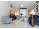 Comfortable living room with tile flooring, vaulted ceiling and view of the screened in patio at 25265 Lost Oak Cir, Leesburg, FL 34748