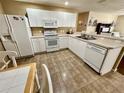 Efficient kitchen design featuring white cabinets and ample counter space for meal preparation at 2910 Barboza Dr, The Villages, FL 32162
