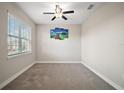 Neutral bedroom with carpet, ceiling fan and a large window for natural light at 3139 Hurston Watch Ln, Clermont, FL 34711