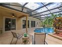 Inviting screened-in pool area with outdoor seating, lush landscaping, and a covered patio at 3430 Turningwind Ln, Winter Garden, FL 34787